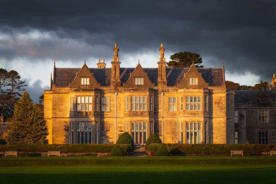 19th-century mansion, Muckross House, during a colorful sunset.